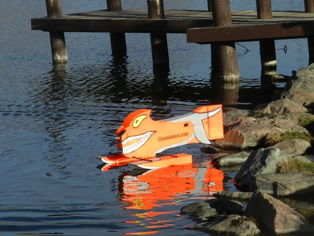 The Goosinator on the water beside a dock